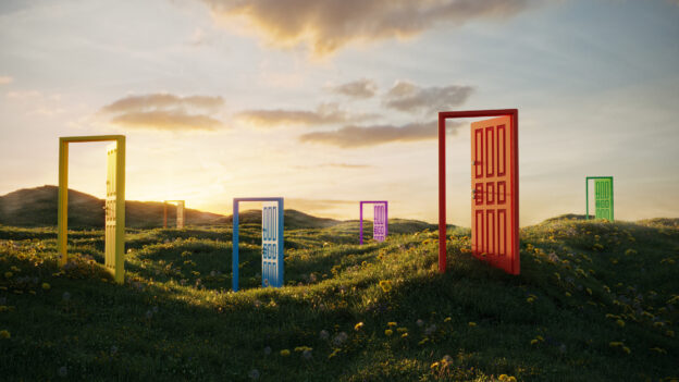 Multi colored abstract opening doors on grassy field on sunny summer day; representing opportunity.